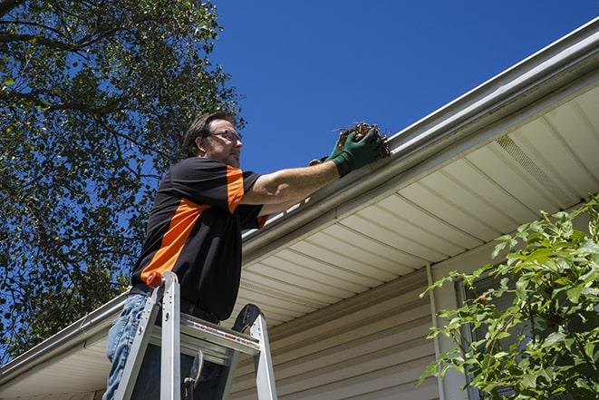 metal gutter pieces being carefully replaced and fixed in Earlimart