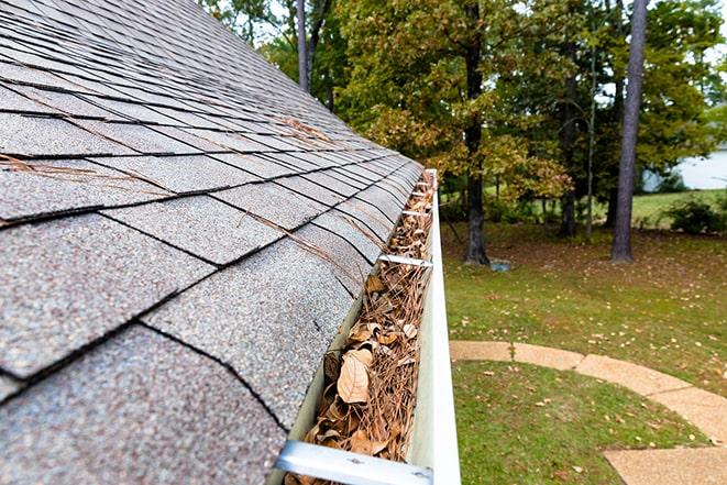 cleaning out gutters to prevent blockages